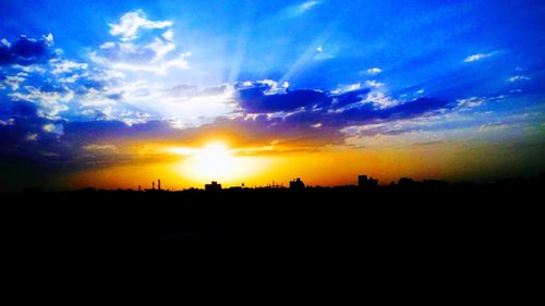 Silhouette landscape against dramatic sky during sunset