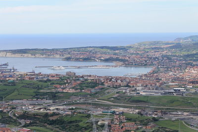 High angle view of townscape by sea against sky