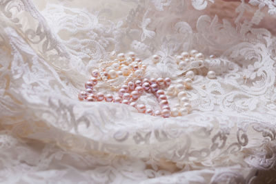 Close-up of pearl jewelry on lace fabric