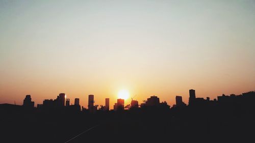 Silhouette buildings against sky during sunset