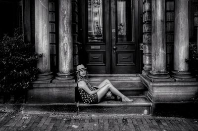 Low section of woman sitting outside building