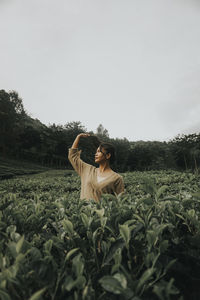 Woman standing on field against sky