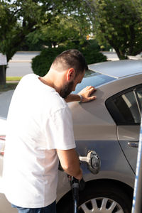 Side view of man holding car