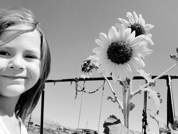 Close-up portrait of smiling girl against blue sky