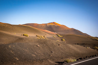 Scenic view of desert against clear blue sky