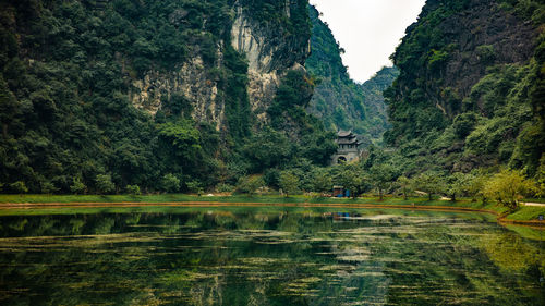 Scenic view of lake by trees against mountain