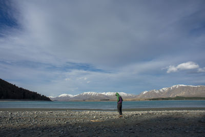 Man standing on beach against sky