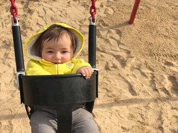 Portrait of cute baby boy sitting on swing