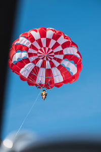 Low angle view of parachute against clear blue sky