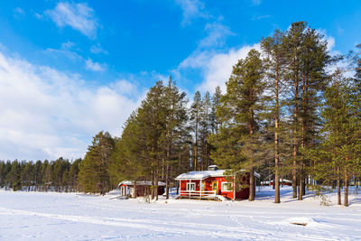 House on snow covered field against sky