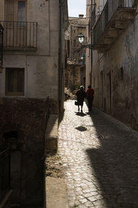 Rear view of people walking on building