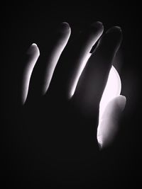 Close-up of human hand against black background