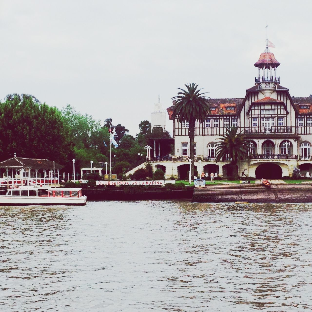 architecture, built structure, building exterior, water, tree, waterfront, sky, river, palm tree, reflection, canal, clear sky, dome, incidental people, travel destinations, outdoors, day, city, travel, tourism