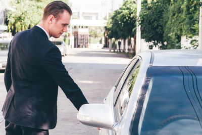 Businessman opening car door