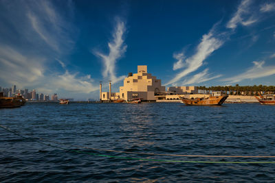 Museum of islamic art , doha, qatar in daylight exterior view with arabic gulf and dhow 