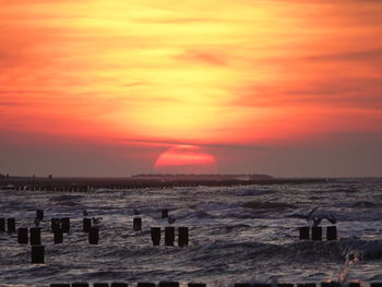 Scenic view of sea against romantic sky at sunset