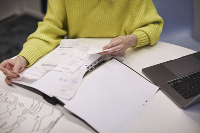 Businesswoman checking receipts in office