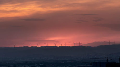 Silhouette of wind turbines at sunset