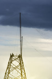 Low angle view of electricity pylon against sky