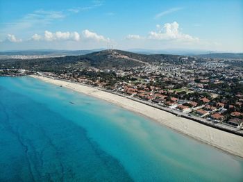 Aerial view of cityscape by sea against sky