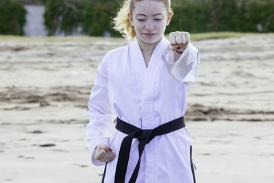 Teenage girl practicing martial arts at beach