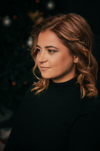 Portrait of beautiful woman against black background