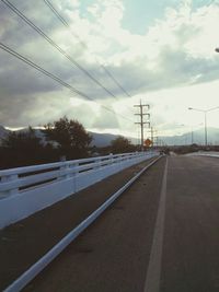 Road by trees against sky