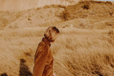 Rear view of woman standing on field