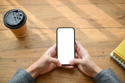 Cropped hand of woman using mobile phone