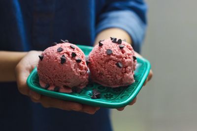 Close-up of hand holding a plate with ice cream