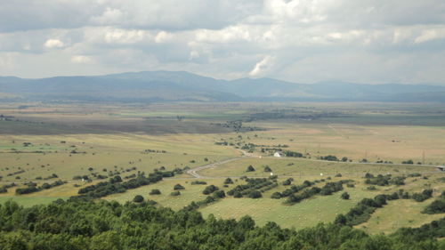 Scenic view of field and mountains against sky