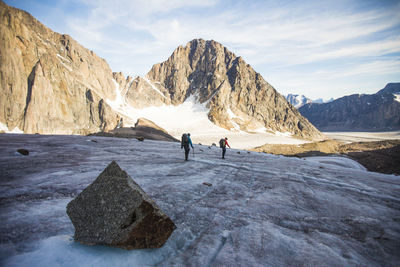 People on snowcapped mountain against sky