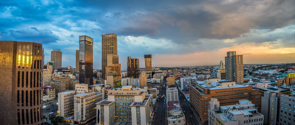 High angle view of buildings in city against cloudy sky