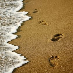 High angle view of footprints on sand at beach