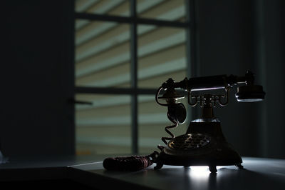 Close-up of electric lamp on table at home