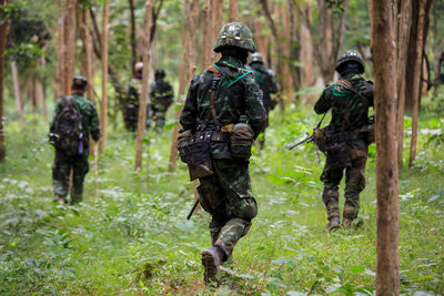 Rear view of boys walking in forest