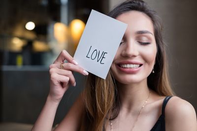 Close-up of smiling young woman with text