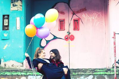 Young couple holding balloons