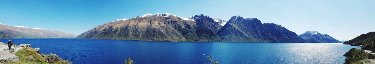 Panoramic view of lake and mountains against blue sky