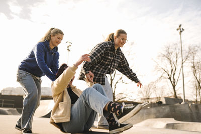 Teenage girls skateboarding in skatepark