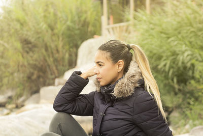 Portrait of beautiful young woman sitting outdoors