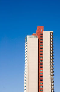 Low angle view of modern building against clear blue sky