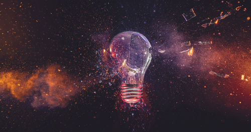 Close-up of illuminated lighting equipment against black background