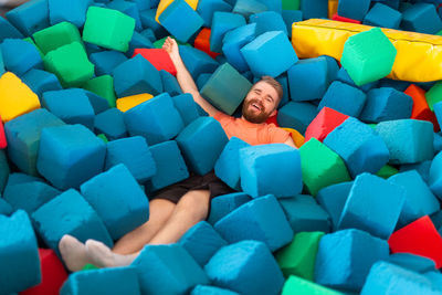 High angle view of woman lying on multi colored umbrellas