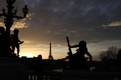 Silhouette statue against sky during sunset