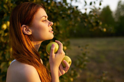 Portrait of young woman holding apple