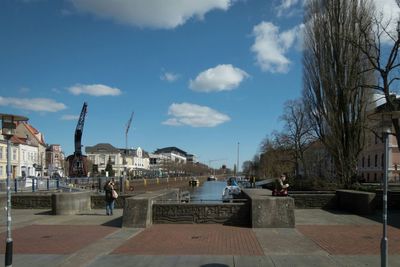 Buildings in town against cloudy sky