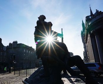 Low angle view of statue against buildings