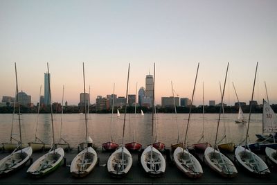 Boats moored at harbor against clear sky