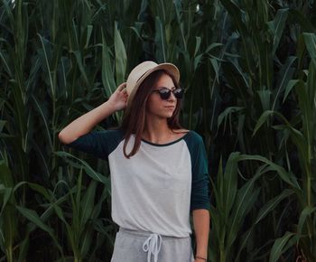 Young woman wearing sunglasses standing on field